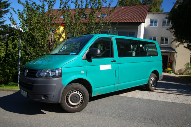 Türkiser Bus steht in der Einfahrt des Zentrums.