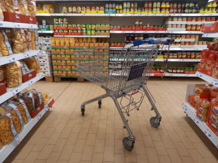 Einkaufswagen steht in der Mitte eines Gangs in einem Supermarkt
